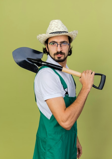 Jardinero de sexo masculino joven serio en gafas ópticas con sombrero de jardinería