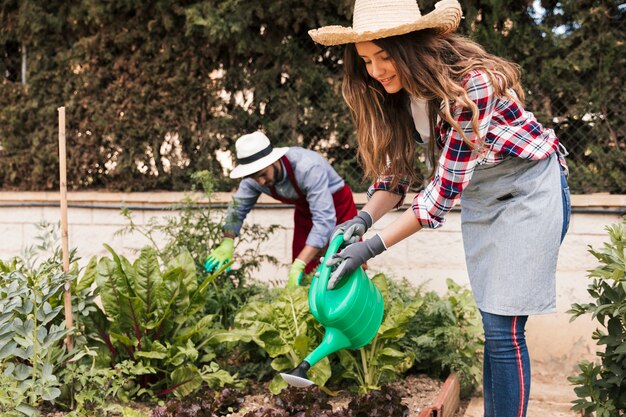 Jardinero de sexo masculino y de sexo femenino que trabaja en el jardín