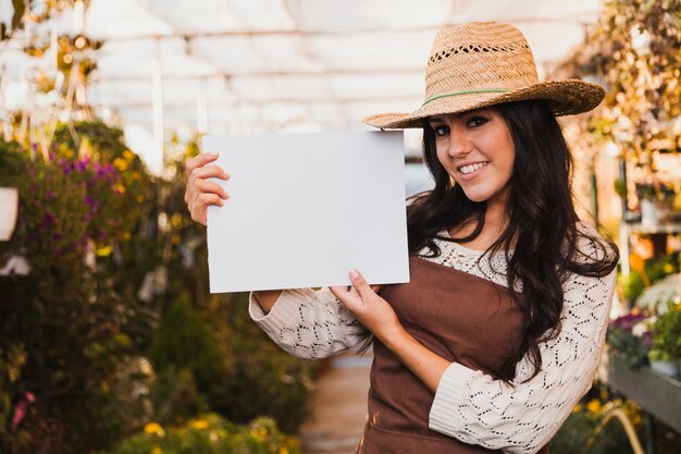 Foto gratuita jardinero sonriente con la hoja de papel