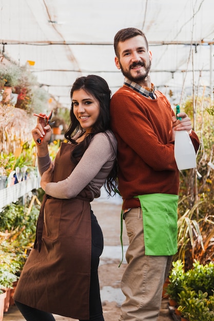 Foto gratuita jardineros alegres con pruner y botella de spray