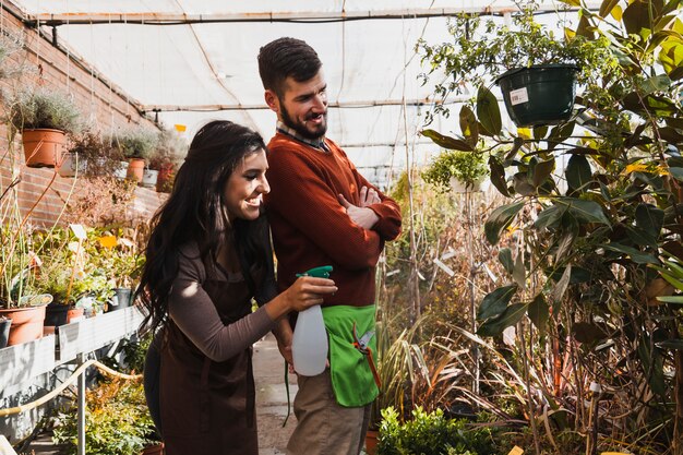 Jardineros alegres rociando plantas