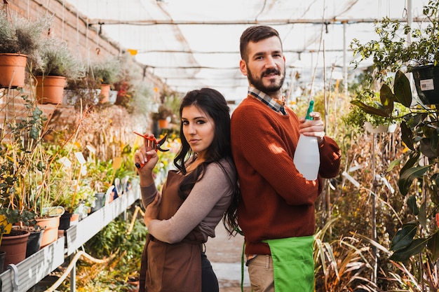 Foto gratuita jardineros con podadora y botella de spray