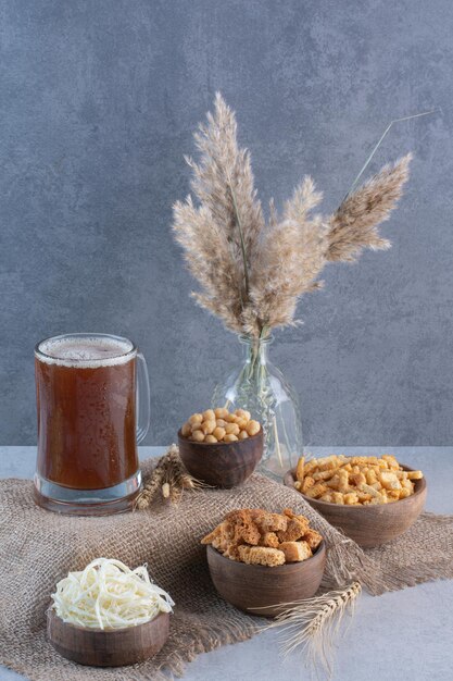 Una jarra de cerveza con palitos de pan y guisantes de cilicio