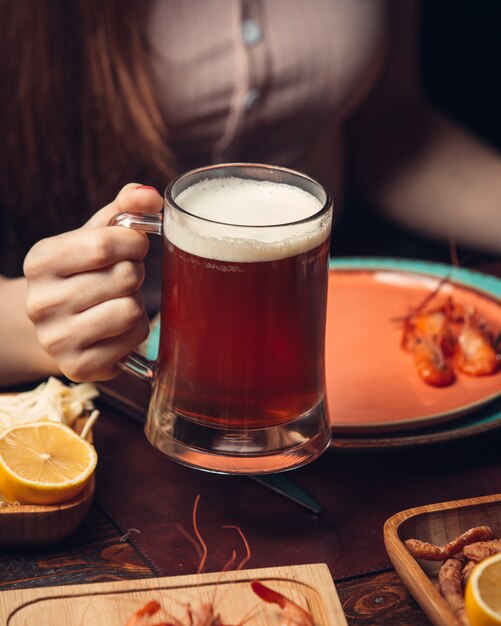 Jarra de cerveza roja con gambas y limón