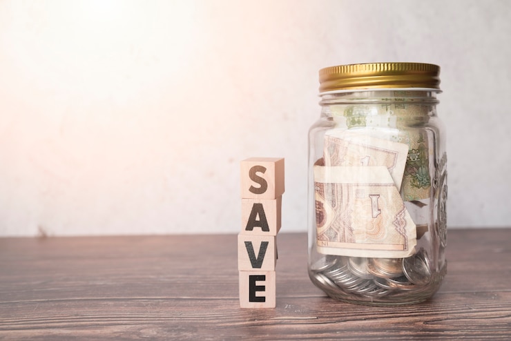 Foto gratuito jarra de cristal para ahorros con palabra de madera