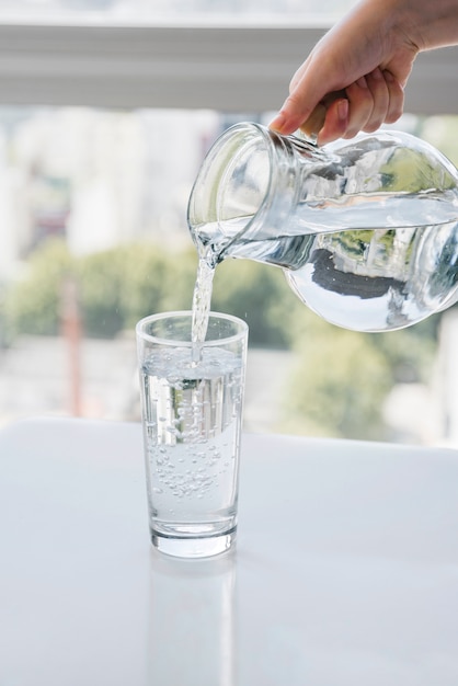 Jarra llenando vaso de agua