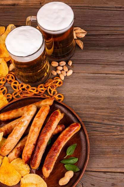 Jarras de cerveza y plato con salchichas