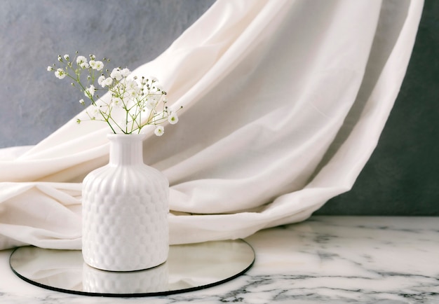 Jarrón de cerámica con flores en la mesa