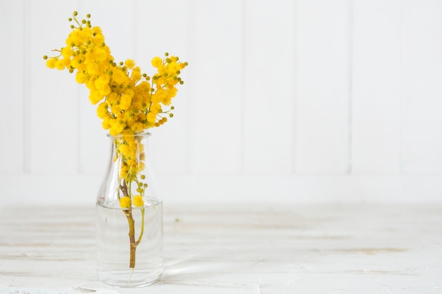 Jarrón de cristal con flores amarillas bonitas