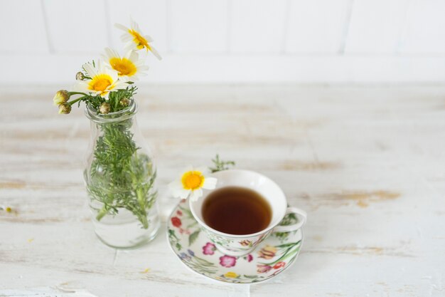 Jarrón decorativo junto a una taza de té