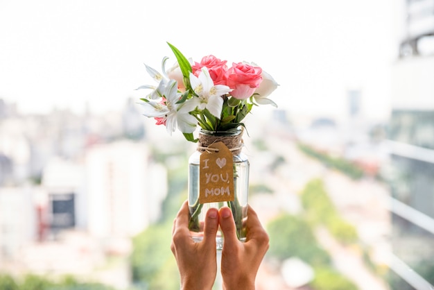 Jarrón de flores para el día de la madre en manos.