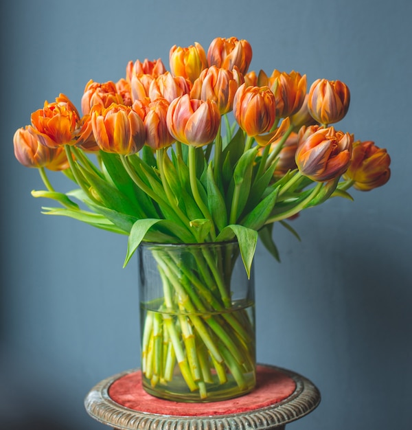 Un jarrón de tulipanes de color naranja.