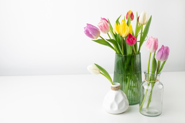 Jarrón con tulipanes en mesa