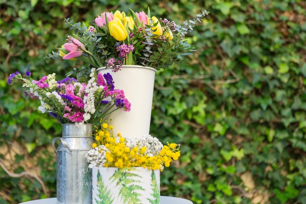 Jarrones con flores bonitas y fondo borroso