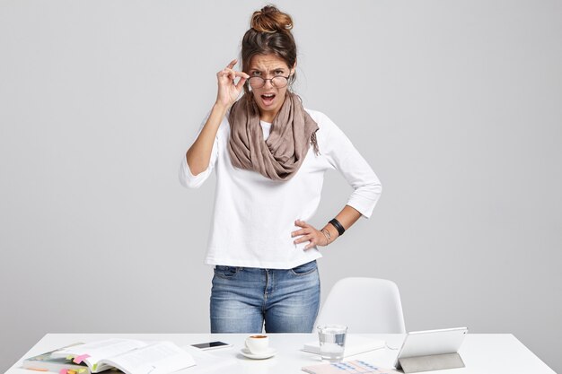 Jefa estricta, mira con enojo a través de gafas, va a gritar