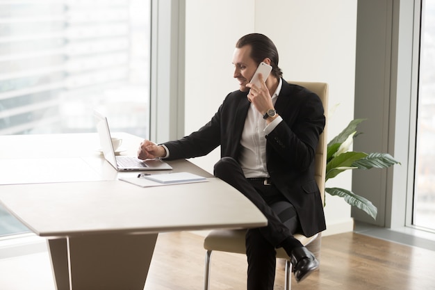 Jefe de empresa en contacto con socios por teléfono.