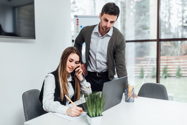 Jefe de mujer con su trabajador gerente escuchando presentación en línea por computadora portátil.