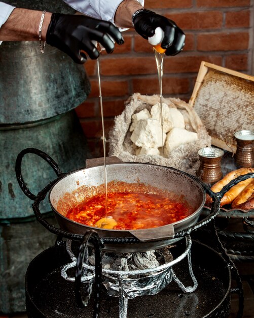 Jefe vierte huevos en tortilla de tomate