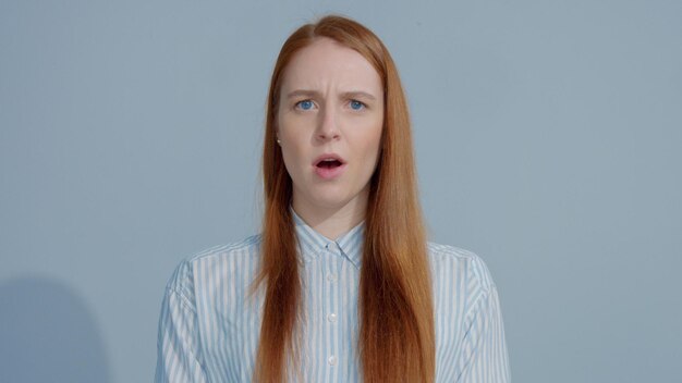 Jengibre cabeza pelo rojo jengibre modelo de pelo con grandes ojos azules en estudio sorprendido y abre la boca Retrato emocional en estudio