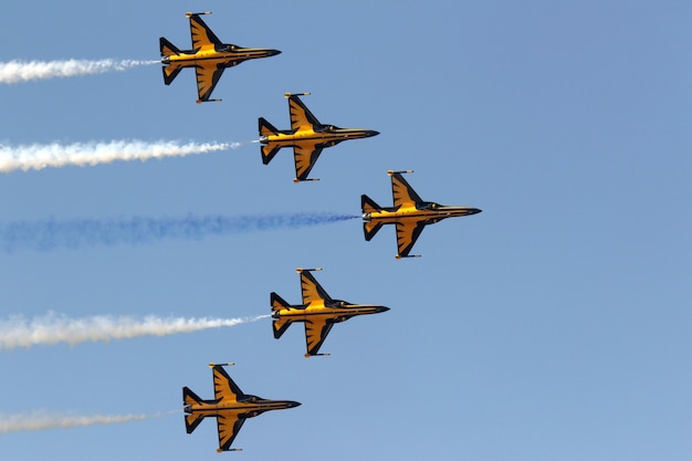 Foto gratuita jets amarillos maniobrando en el cielo durante un desfile aéreo