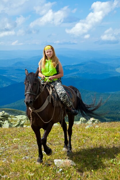 Jinete a caballo en las montañas