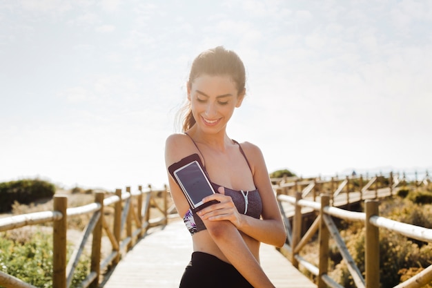 Foto gratuita jogging mujer con smartphone en brazo