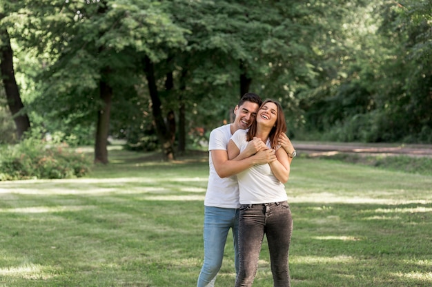 Joven abrazando a su novia en el parque