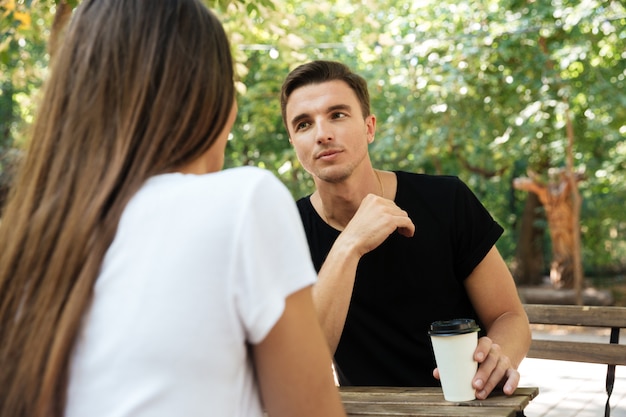 Joven aburrido sentado y tomando café