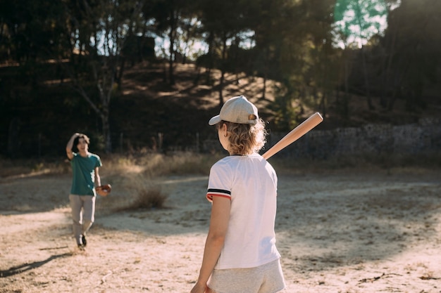 Joven activo y una mujer jugando béisbol al aire libre