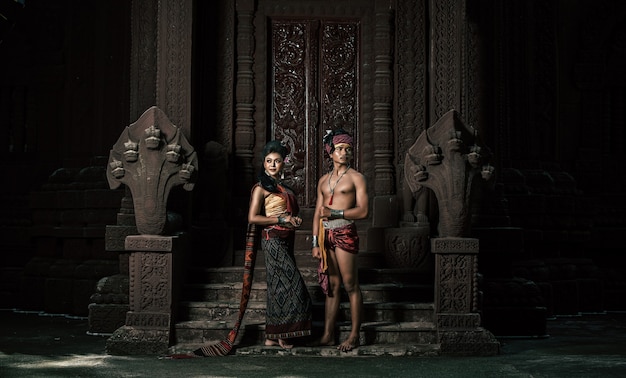 Joven actor y actriz con hermosos trajes antiguos, en monumentos antiguos, estilo dramático. Actuar en la leyenda de una historia popular de amor, un cuento popular tailandés de Isan llamado "Phadaeng y Nang-ai" en un sitio web.