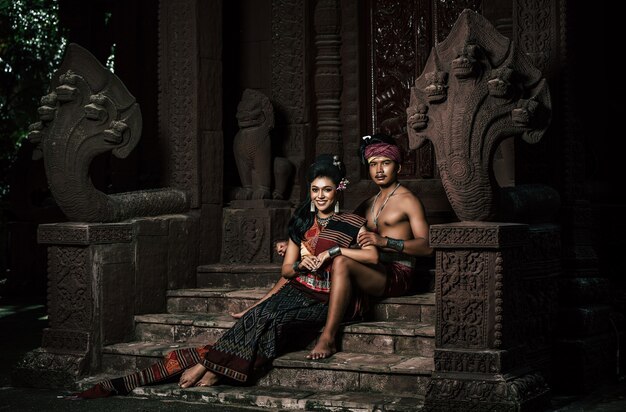 Joven actor y actriz con hermosos trajes antiguos, en monumentos antiguos, estilo dramático. Actuar en la leyenda de una historia popular de amor, un cuento popular tailandés de Isan llamado "Phadaeng y Nang-ai" en un sitio web.