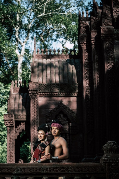 Joven actor y actriz con hermosos trajes antiguos, en monumentos antiguos, estilo dramático. Actuar en la leyenda de una historia popular de amor, un cuento popular tailandés de Isan llamado "Phadaeng y Nang-ai" en un sitio web.