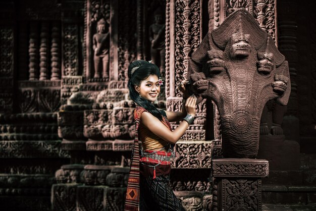 Joven actriz vestida con hermosos trajes antiguos, en monumentos antiguos, estilo dramático. Actuar en la leyenda de una historia popular de amor, un cuento popular tailandés de Isan llamado "Phadaeng y Nang-ai" en un sitio web.