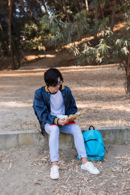 Joven adolescente étnico estudiando en el parque