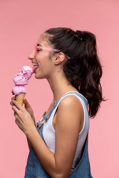 Joven adolescente con gafas de sol comiendo un helado