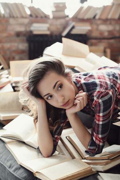 Joven adolescente leyendo un libro en casa