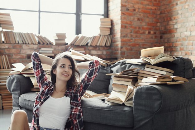 Joven adolescente leyendo un libro en casa