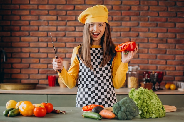 Joven adolescente preparando ensaladas para el desayuno en la cocina