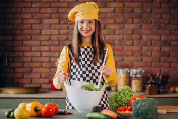 Joven adolescente preparando ensaladas para el desayuno en la cocina