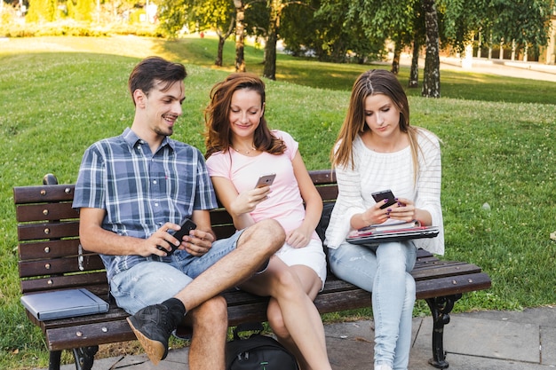 Joven adolescentes con teléfonos en el parque