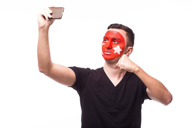 Joven aficionado al fútbol de Túnez hombre hacer selfie aislado en la pared blanca