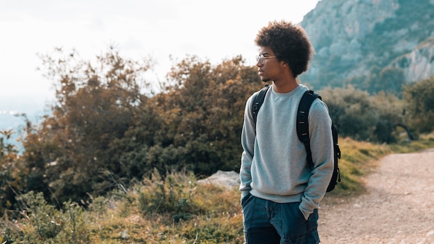 Un joven africano con las manos en el bolsillo mirando la vista