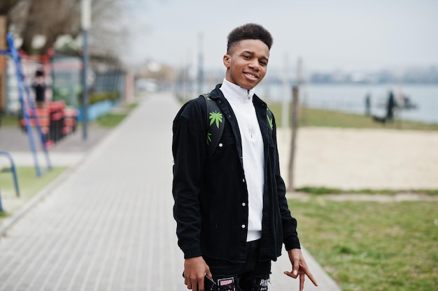 Joven africano milenario caminando en la ciudad Hombre negro feliz con mochila de marihuana Concepto de Generación Z