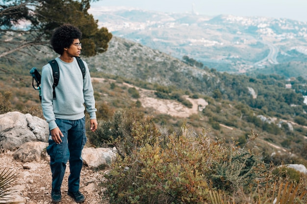 Foto gratuita un joven africano con vistas a la montaña