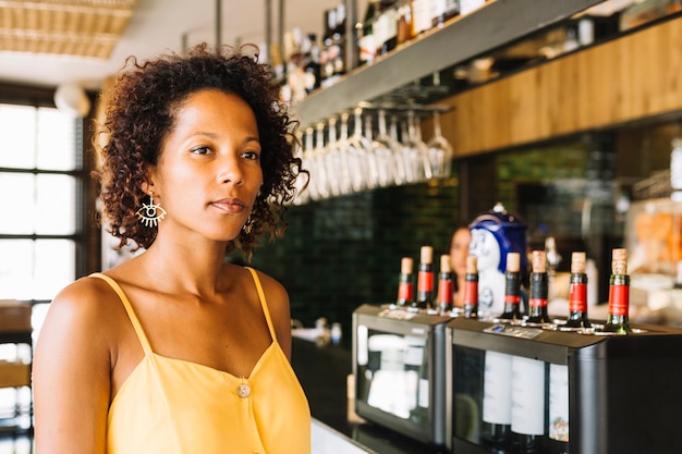 Foto gratuita una joven afroamericana en barra de bar