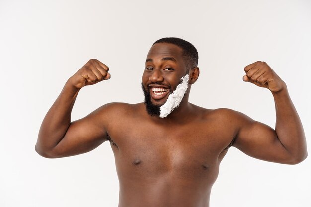 Joven afroamericano afeitándose en el baño rutina personal de higiene matutina en el concepto matutino