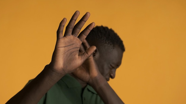 Foto gratuita joven afroamericano asustado posando asustado en la cámara sobre un fondo colorido no quiero ver la expresión