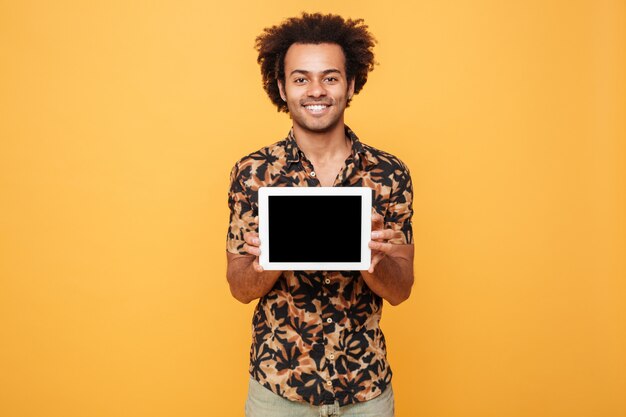 Joven afroamericano feliz mostrando tableta de pc de pantalla en blanco