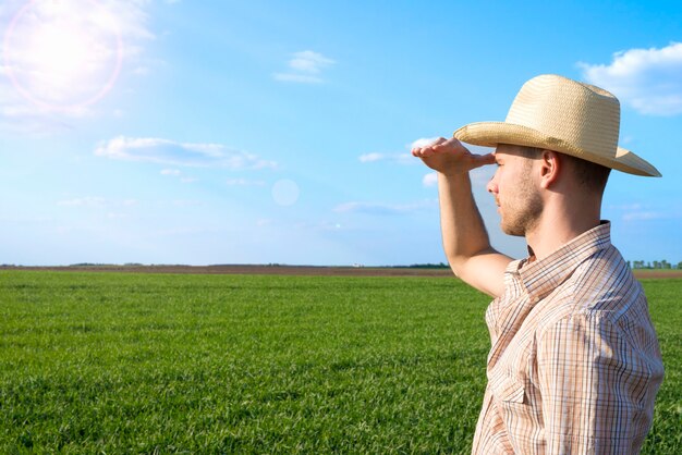 Joven agricultor en el campo observando cultivos