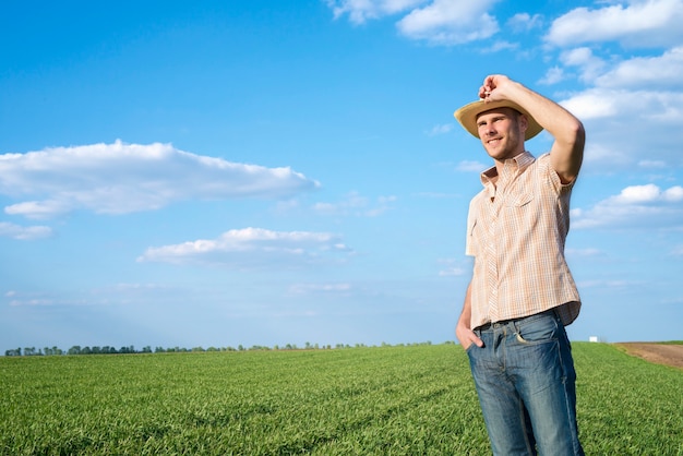 Joven agricultor en el campo observando cultivos